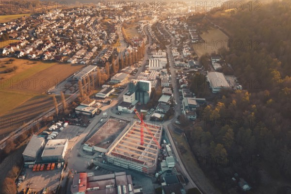 Panoramic view of an urban building area with crane and surrounding residential areas at sunset, Rewe new building, Aidlingen, Böblingen district, Germany