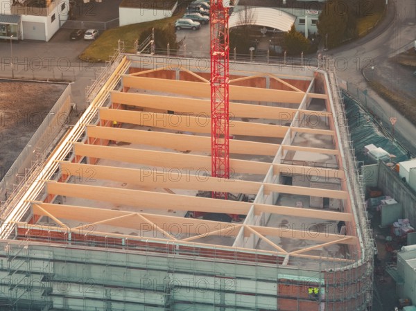 Close-up of a construction site with visible building structure and crane in warm light, Rewe new building, Aidlingen, Böblingen district, Germany