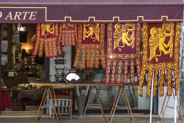Flags of the Republic of Venice hang for sale in front of a shop, Venice, Veneto, Italy