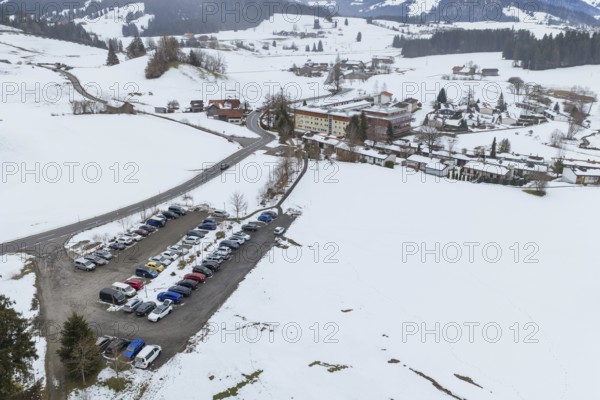 Parking lot full of cars in a snowy, hilly winter landscape from above, specialist clinic for psychosomatics and psychotherapy, Hochgrat Clinic, Stiefenhofen, Bavaria, Germany