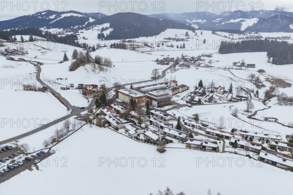 Wintery mountain village surrounded by snow-covered roads and mountains taken from the air, specialist clinic for psychosomatics and psychotherapy, Hochgrat Clinic, Stiefenhofen, Bavaria, Germany
