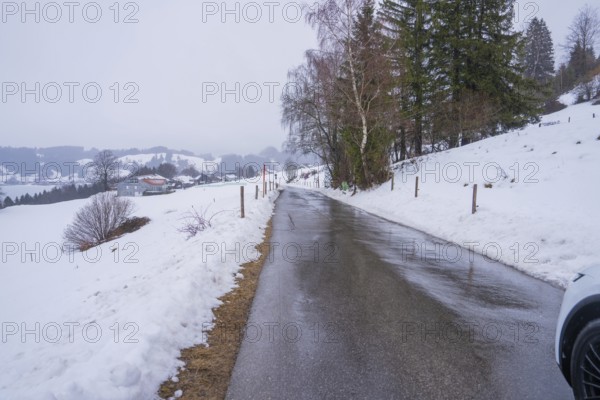 Snowy street with trees on the sides and quiet winter atmosphere, specialist clinic for psychosomatics and psychotherapy, Hochgrat Clinic, Stiefenhofen, Bavaria, Germany