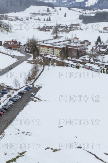 Snow-covered village with parking space in the midst of a winter landscape seen from the air, specialist clinic for psychosomatics and psychotherapy, Hochgrat Clinic, Stiefenhofen, Bavaria, Germany