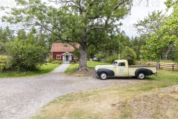 Typical Sweden, Swedish red country house and old car, Virum Älkpark near Vimmerby, Kalmar län, Sweden