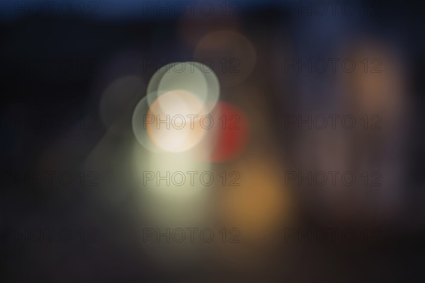 Colourful lights illuminate the city street at night. The scenes are blurred and there is movement. The atmosphere is dynamic and lively. Bas rhin, Alsace, France