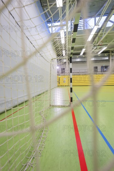A handball goal and net in a large empty sports hall from a side view, Handball, Calw, Germany