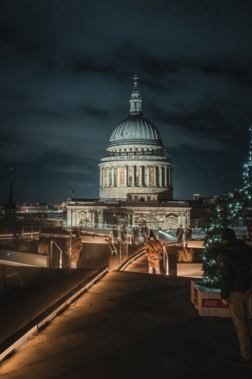 Atmospheric view of illuminated St. Paul's Cathedral from a roof terrace with Christmas decorations, London, Great Britain