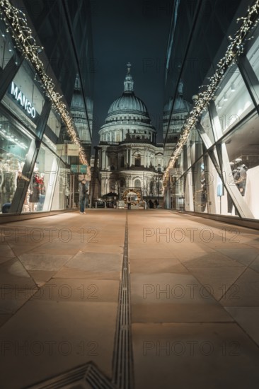 View of illuminated St. Paul's Cathedral through modern glass facades at night, London, Great Britain