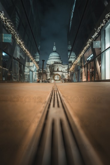 Central view of cathedral at night through symmetrical modern facades, London, United Kingdom