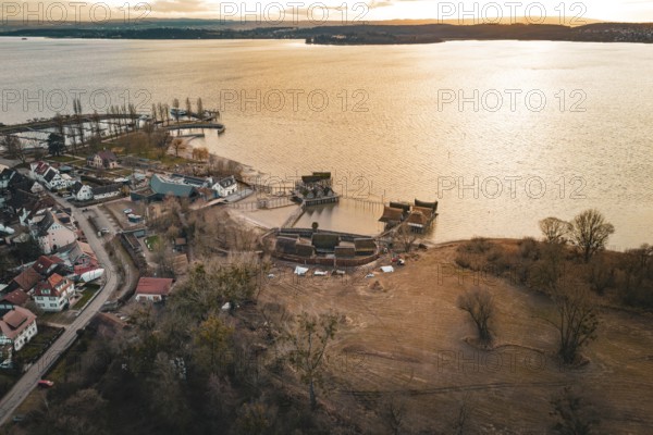 Extensive view with a lake, traditional stilt houses and warm sunset light, stilt houses Unteruhldingen, Bodenseekreis, Germany