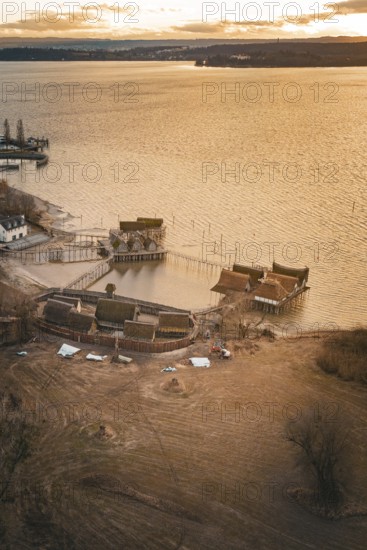 Historic stilt houses on the shore of a lake at sunset with warm light and peaceful atmosphere, stilt houses Unteruhldingen, Bodenseekreis, Germany