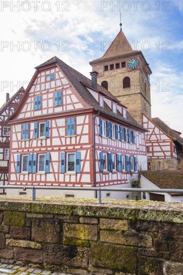 Half-timbered building and church tower with clock and blue shutters, traditional ambiance, Ötisheim, Enzkreis, Germany