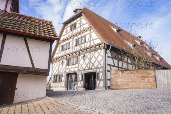 Timbered house with tiled roof and cobblestone road under blue sky, Ötisheim, Enzkreis, Germany