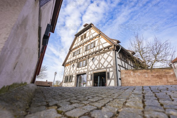 Timbered house on cobblestone road, traditional style under blue sky, Ötisheim, Enzkreis, Germany