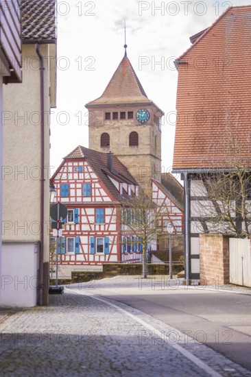 Street scene with view of half-timbered house and church tower with clock, Ötisheim, Enzkreis, Germany