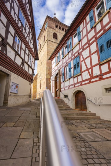 Historic half-timbered houses with church tower and stairs, sunny weather, Ötisheim, Enzkreis, Germany