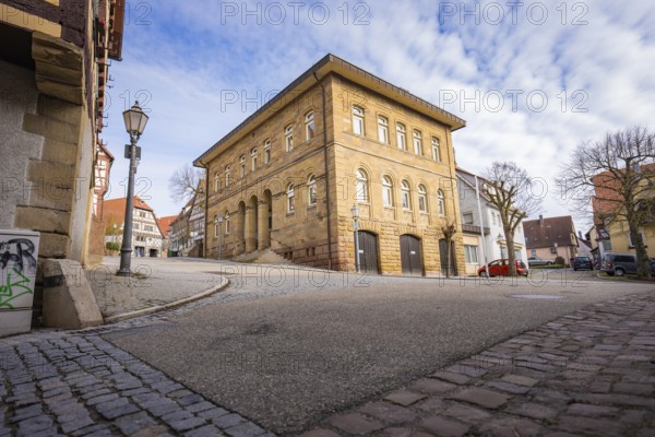 Historic building and wide cobblestone street with lanterns under blue sky, Ötisheim, Enzkreis, Germany