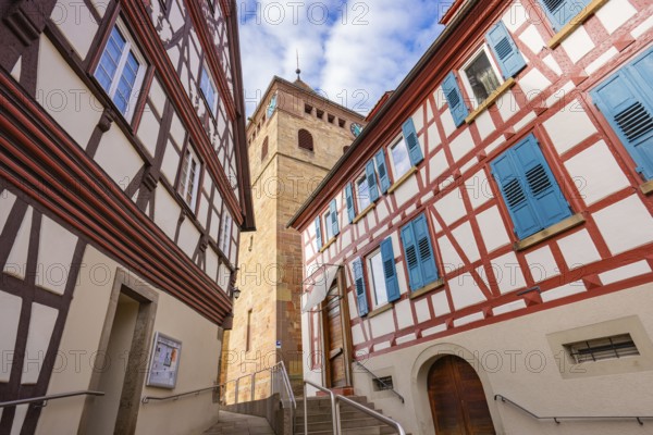 Historic half-timbered houses with blue shutters and tower view in a narrow lane, Ötisheim, Enzkreis, Germany