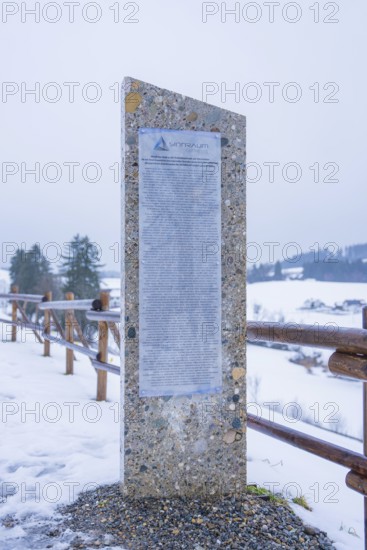Stone monument with text board on a snowy path in winter, Sinnraum, Oberreute, Allgäu, Bavaria, Germany