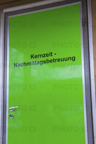 Green door with inscription for core time afternoon care, easy entrance, homework supervision, Schlehengäu elementary school Gechingen, Calw district, Germany
