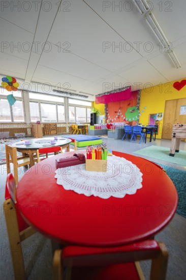 Creative environment in a kindergarten with round table and colored pencils, colorful decoration, homework supervision, Schlehengäu Grund Schule Gechingen, Calw district, Germany