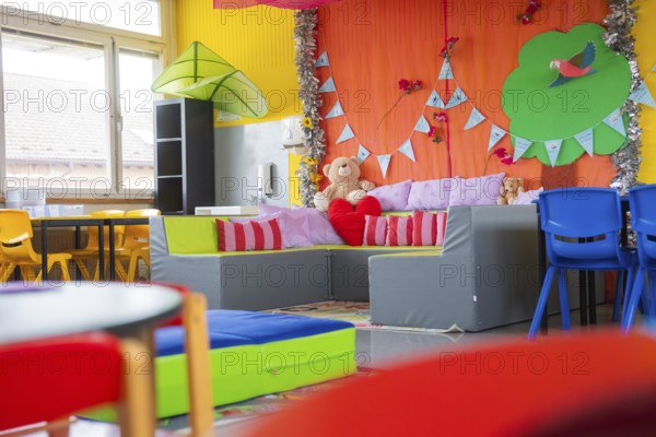Child-friendly seating area with cuddly toys and colorful pillows, decorative elements in the background, homework supervision, Schlehengäu Grund Schule Gechingen, Calw district, Germany