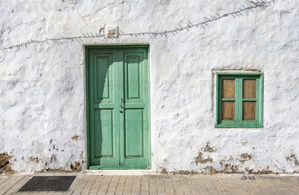 Typical white house with turquoise wooden door and window in an alley, Teguise, Lanzarote, Canary Islands, Spain