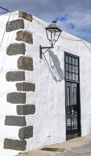 Typical white house with wooden door and alleyway lamp in an alley, Teguise, Lanzarote, Canary Islands, Spain