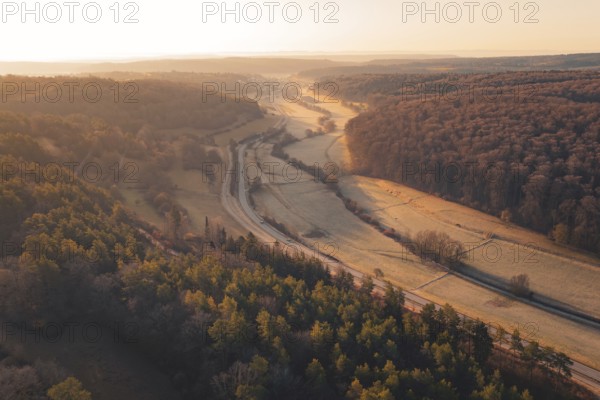 Wooded valley view at sunset with a road snaking through the rolling hills, Gechingen, Calw County, Germany