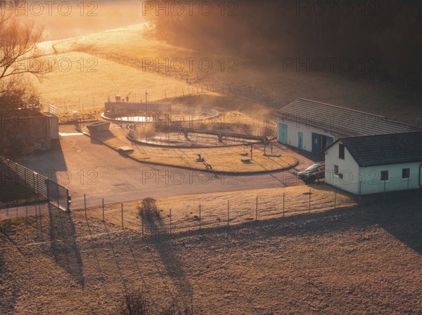 Sewage treatment plant in a meadow in soft sunlight, with fog and shade, quiet and idyllic, Gechingen, Calw district, Germany