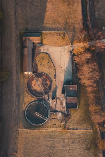 Top view of a sewage treatment plant with round basin surrounded by an autumnal landscape, Gechingen, Calw district, Germany