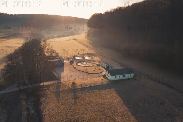 Early morning atmosphere with rays of light on sewage treatment plant in a rural area, Gechingen, Calw district, Germany