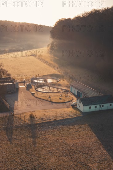 Wastewater treatment plant in a rural area in morning light with long shadows and light fog, Gechingen, Calw district, Germany