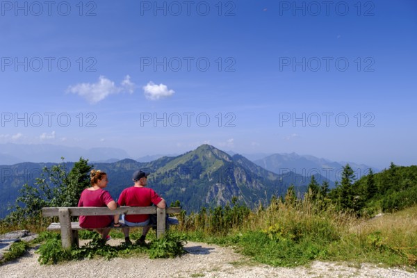 Hikers, mountaineers on a rest bench, in the summit area, at Hochfelln, near Bergen, Chiemgau, Upper Bavaria, Bavaria, Germany