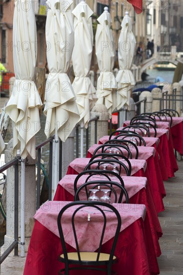 Tables set on the canal of a restaurant, Venice, Veneto, Italy