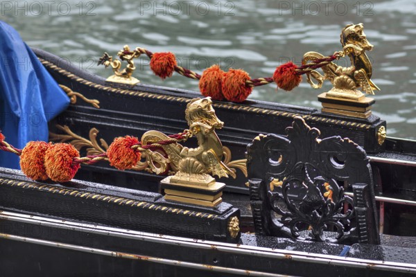Gold-colored mythical animals decorate the gondola, Venice, Veneto, Italy