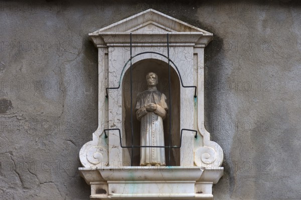 Sculpture of a priest in a niche at a residential building, Venice, Veneto, Italy