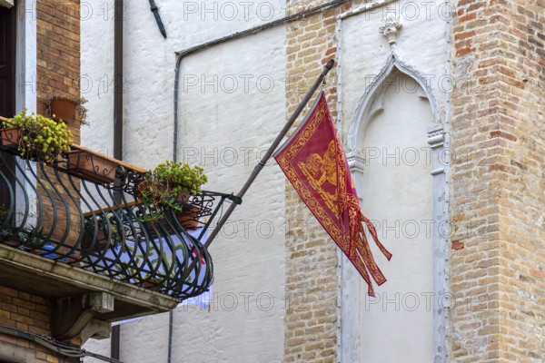 Waving Venetian flag on a balcony, Venice, Veneto, Italy