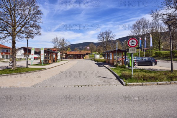 Inzell bus station, bus shelter, bus platform, traffic sign prohibition for motor vehicles and motor vehicles with additional sign public transport free, parking with cars, general architecture, residential buildings, bare winter trees, hilly landscape, coniferous forest, blue sky, cirrus clouds, cirrostratus clouds, Traunsteiner Straße, Inzell, district of Traunstein, Bavaria, Germany