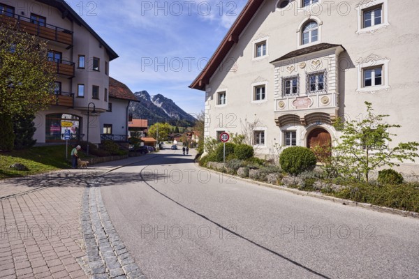 Adlerkopf mountain, houses, general architecture, façade with bay window, windows and façade painting, flower bed, bushes, Tempo 30 sign, blue sky, cirrostratus clouds, intersection of Reichenhaller Straße, Schmelzer Straße with Traunsteiner Straße, Inzell, Traunstein district, Bavaria, Germany