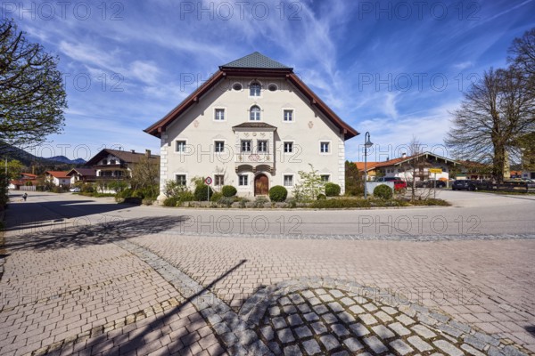 Houses, alpine buildings, general architecture, façade with bay window, windows and façade painting, crippled hipped roof, lantern, hilly landscape, bare winter trees, blue sky, cirrus clouds, cirrostratus clouds, intersection of Reichenhaller Straße, Schmelzer Straße with Traunsteiner Straße, Inzell, district of Traunstein, Bavaria, Germany