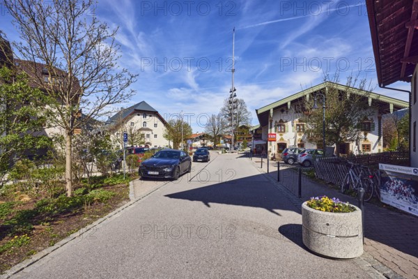 Maypole, alpine buildings, general architecture, houses, barrier bollards, flower pots, parking strips with cars, bare winter trees, blue sky, cirrus clouds, cirrostratus clouds, Reichenhaller Straße, Inzell, Traunstein district, Bavaria, Germany