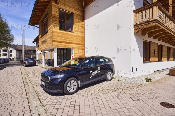 Car with advertising lettering Inzell, town hall, alpine buildings, commercial buildings, building material wood, entrance area, bare winter tree, blue sky, cirrostratus clouds, Rathausplatz square, Inzell, Traunstein district, Bavaria, Germany