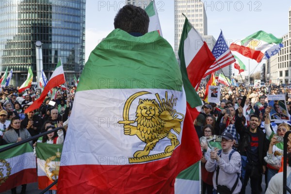 Iranians demonstrate on the day of the US and Israeli attack on Iran, Berlin, 28.02.2026. People wave flags of the Iranian monarchy, German, Israeli and US flags, Berlin, Berlin, Germany