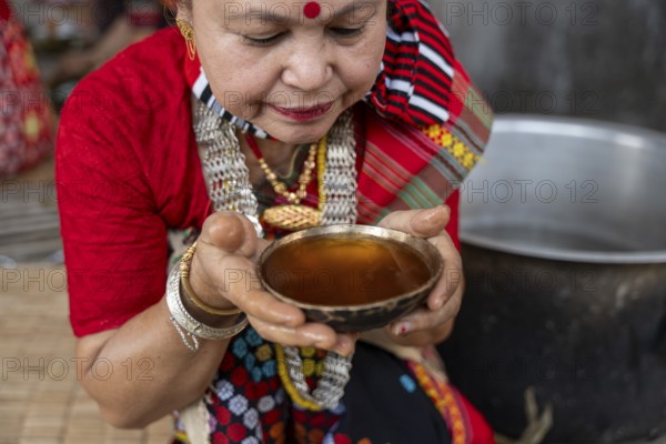 A Mising tribal woman having traditional rice beer 'Aapong' during Ali-Aye-Ligang festival in Guwahati, Assam, India on 18 February 2026. Ali-Aye-Ligang celebrates the Mising community's sowing season with traditional dance, rituals, feasting, and prayers for a prosperous harvest