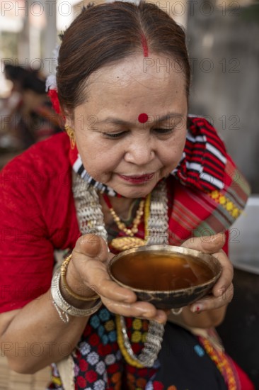 A Mising tribal woman having traditional rice beer 'Aapong' during Ali-Aye-Ligang festival in Guwahati, Assam, India on 18 February 2026. Ali-Aye-Ligang celebrates the Mising community's sowing season with traditional dance, rituals, feasting, and prayers for a prosperous harvest