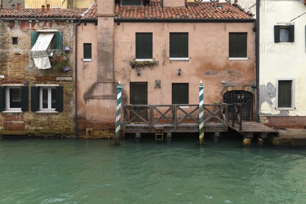 Old houses on the canal with boat dock, Venice, Veneto, Italy