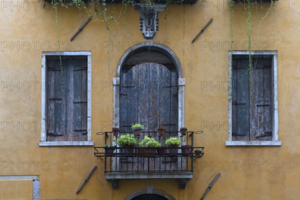 Closed windows and balcony of an old residential building in the old town, Venice, Veneto, Italy