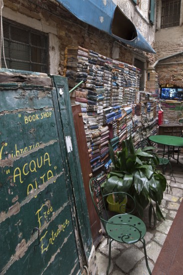 Stacked books on a wall after flood damage in a bookstore, Venice, Veneto, Italy