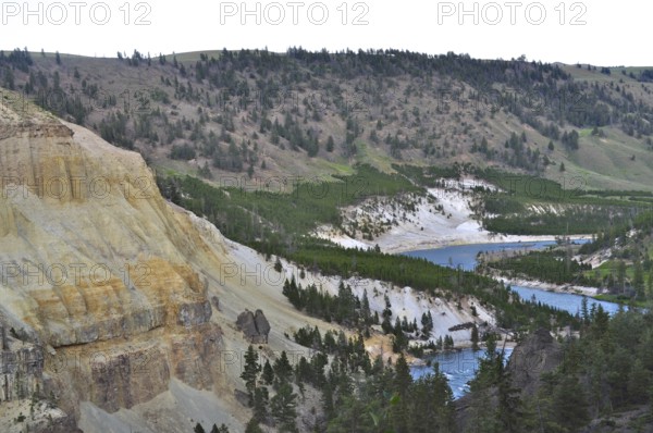 Wide landscape with a river snaking through wooded hills and steep cliffs, Yellowstone National Park, Wyoming, USA